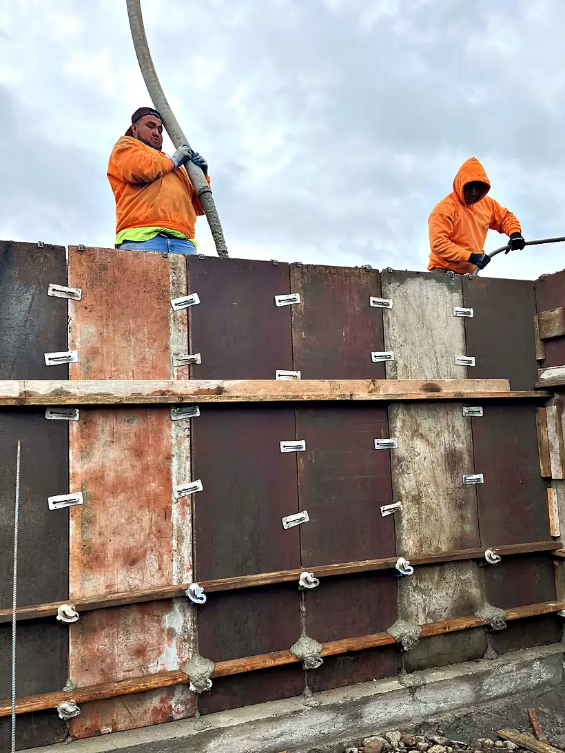 Reyes Brothers crew on wall forms during a concrete foundation pour