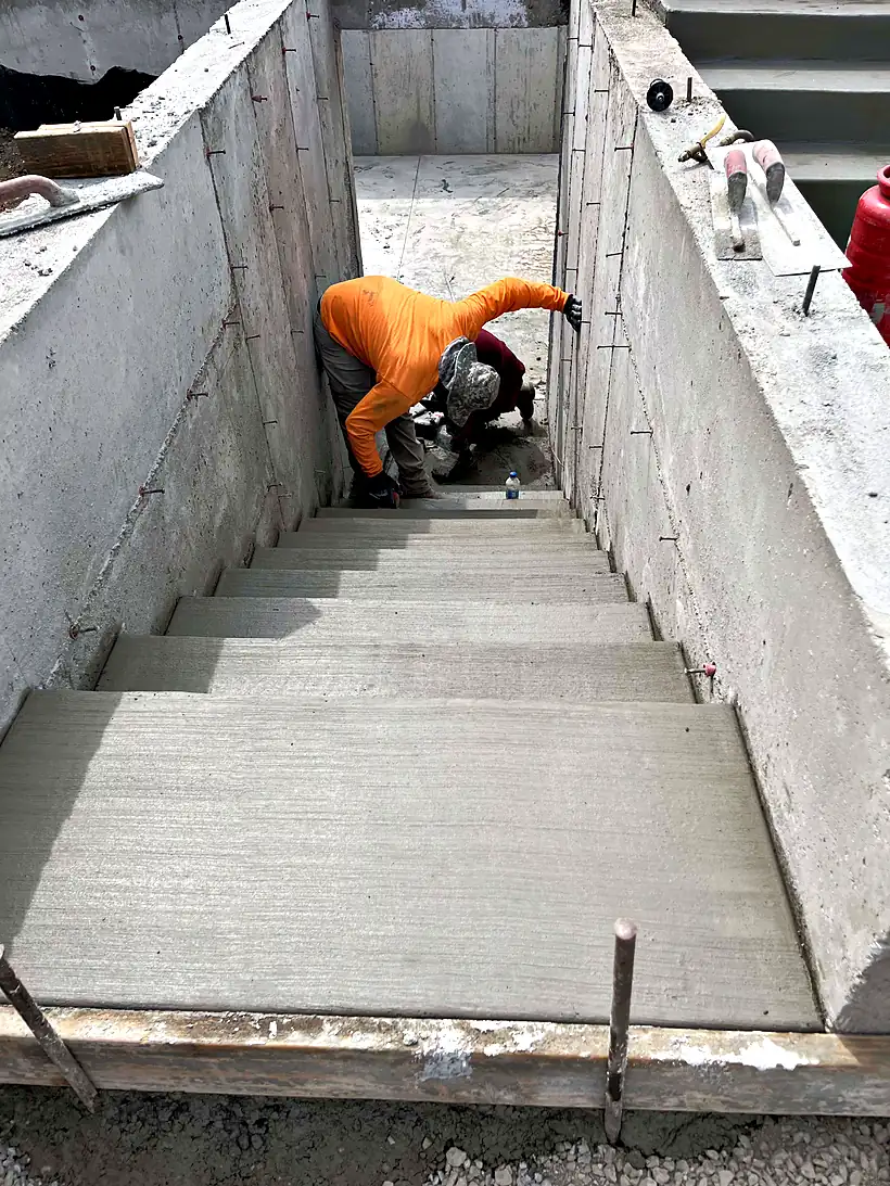 A Reyes Brothers crew member working inside wooden forms for a set of concrete steps